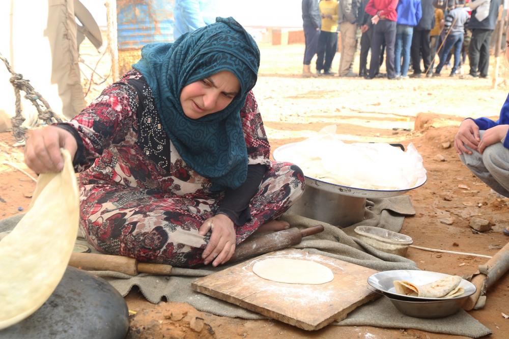 An internally displaced woman cooks a meal in the remote camp in Rukban on the border with Jordan. Photo: WFP Syria/ Marwa Awad