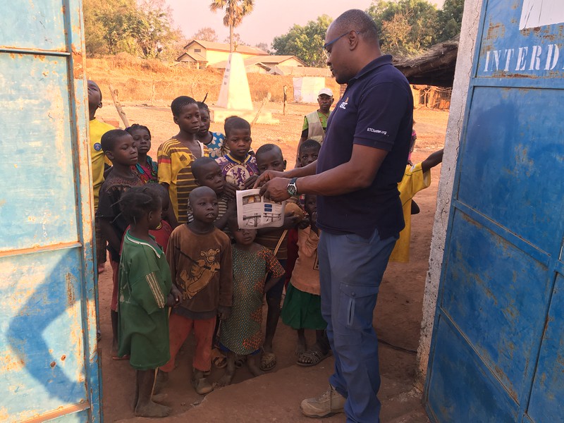 ETC representative Sylvain Tiako explains security communications to a group of children in Batangafo, Central African Republic, in January. Photo: WFP