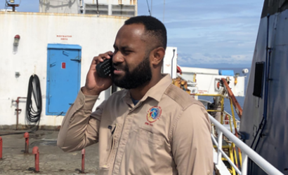 A communications officer from the Fiji National Disaster Management Office (NDMO) contacts the Ministry of Meteorology, Energy, Information, Disaster Management, Environment, Climate Change and Communications (MEIDECC) in Tonga from a Fijian emergency response supply vessel via WFP satellite phone. Photo: Fiji NDMO