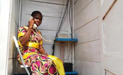 A displaced woman uses one of the new phone booths at the PK3 IDP site in Bria to stay in contact with her family. ©WFP/Elizabeth Millership, Bria, Haute-Kotto Prefecture, CAR, 2021.