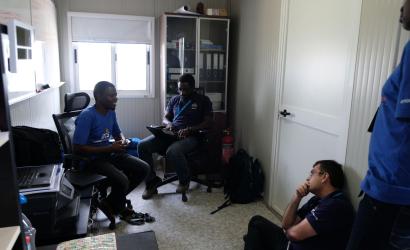 Jalal Shah (lower right), meets with Muhammad Kalli (left) and Ekue Ayih (centre) at the IOM hub in Dikwa. Photo: WFP / Erika Iglesias